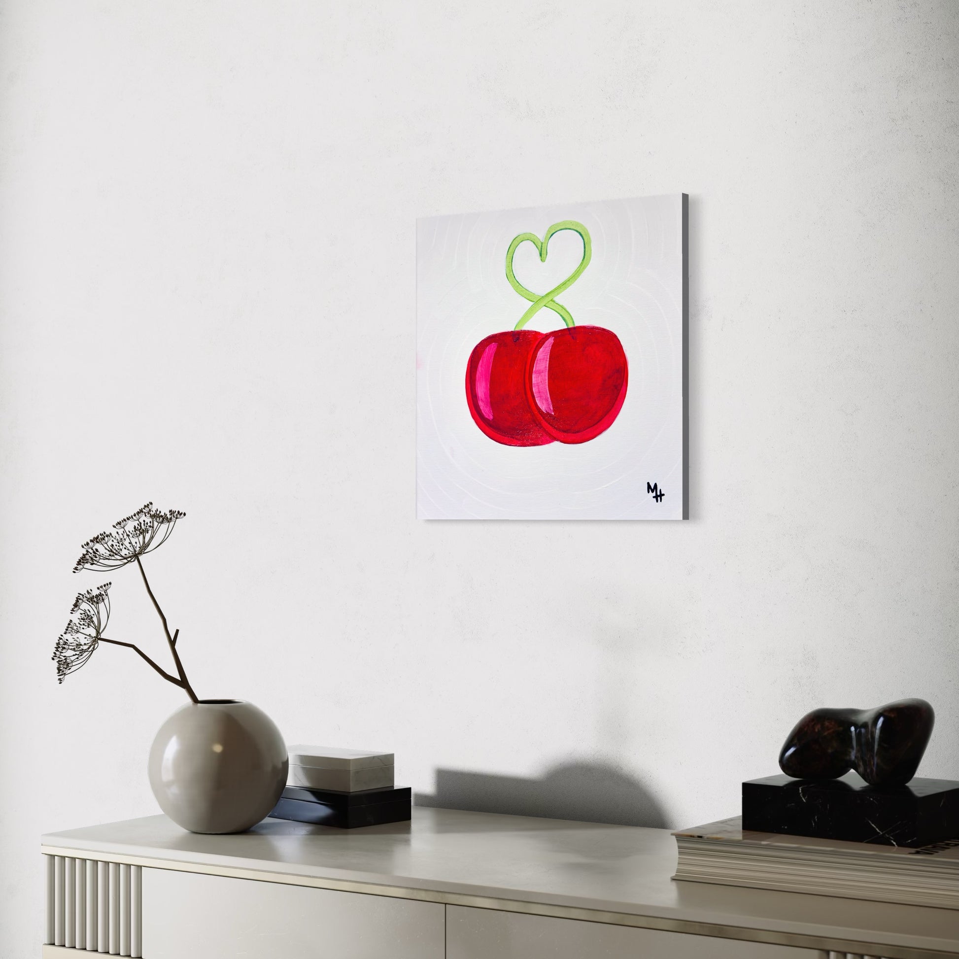 Modern interior with a painting of red cherries on a white wall.