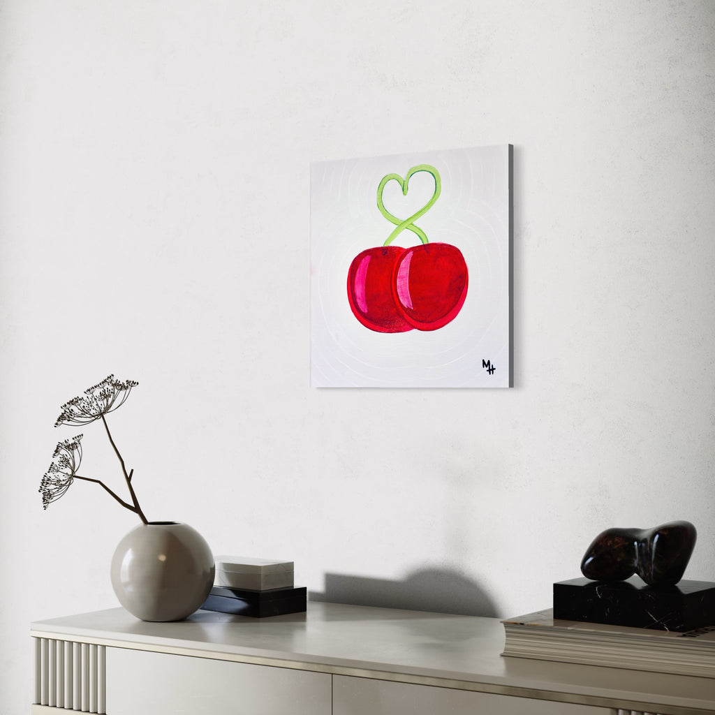 Modern interior with a painting of red cherries on a white wall.